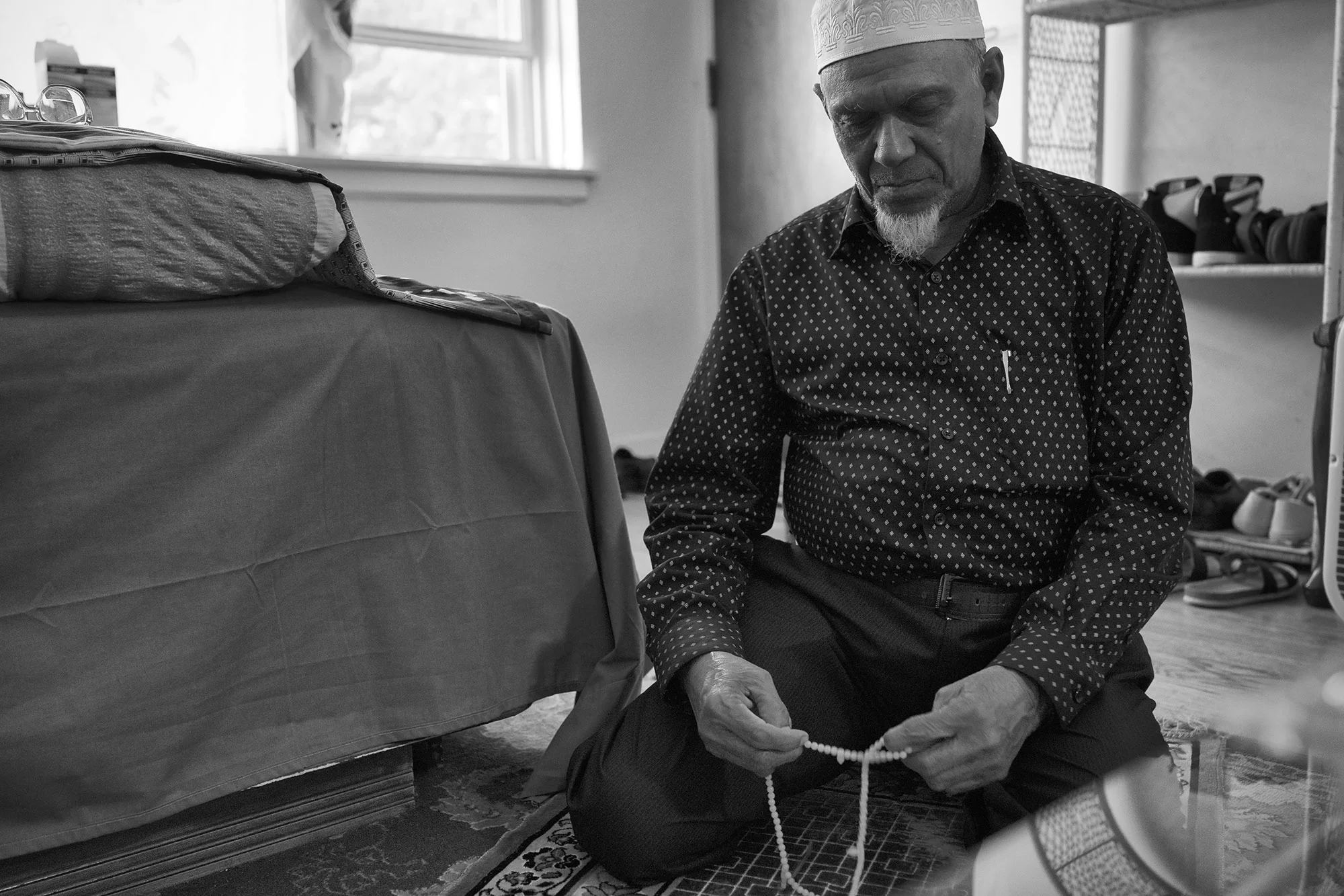 Mohammed pays in his living room. Since the United States offered him citizenship, he views the US as his country. “When I pray, it’s to protect the US government – for peace here and unity. This is the most at-home I’ve felt.” 
