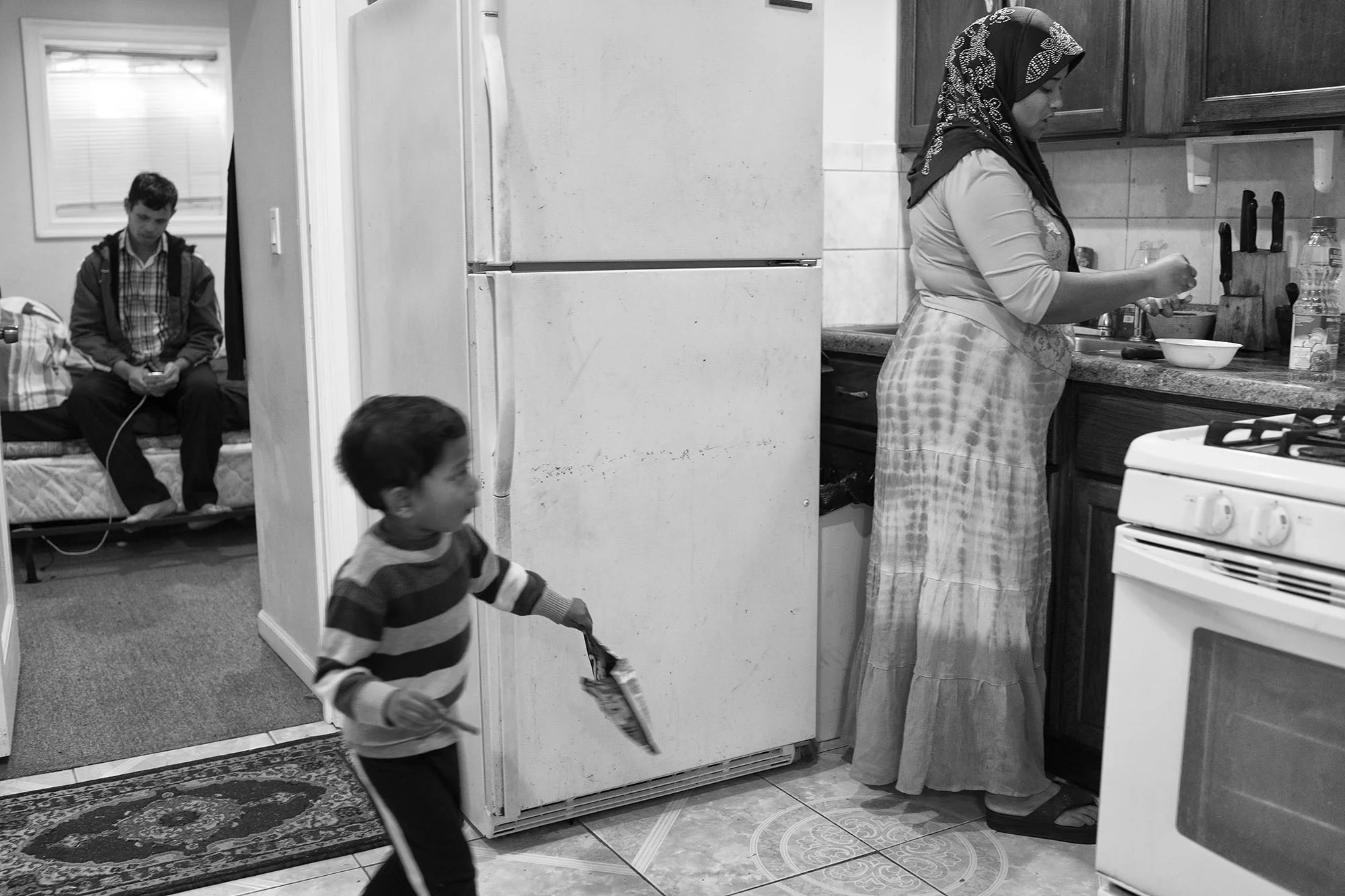 Abdris checks his phone while his wife, Kulsama, makes dinner. His children are spread across Southeast Asia, some having left Myanmar, some still trying to leave. Upon arriving to Chicago, one of his children told Abdris that Lailah had passed away. Soon after, he was introduced to Kulsama, also a widow and with three kids, by members of the local Rohingya community. Kulsama recalls the courtship as pragmatic, with Abdris saying, “I don’t have a wife and you don’t have a husband. We should be married." She admitted that she liked him, which made the offer more appealing.