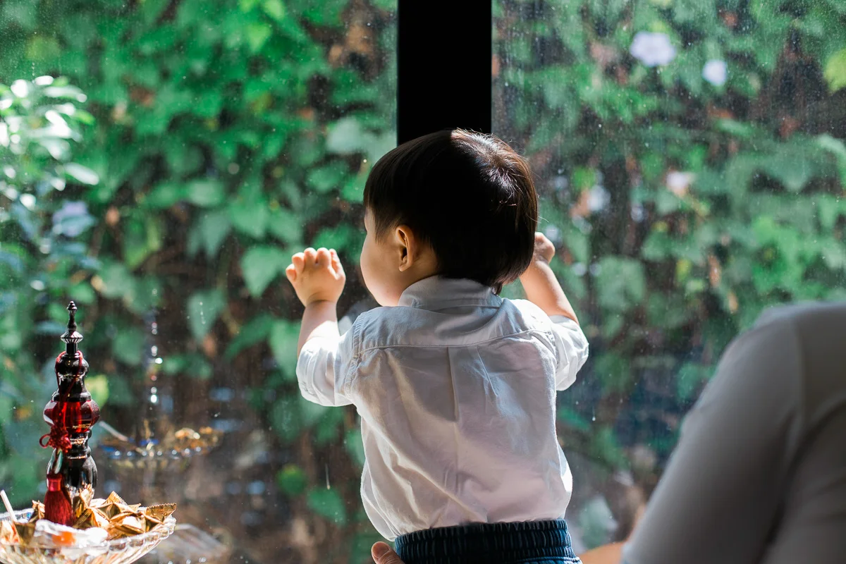 A little boy looks out a window during a family photoshoot in Kuala Lumpur.