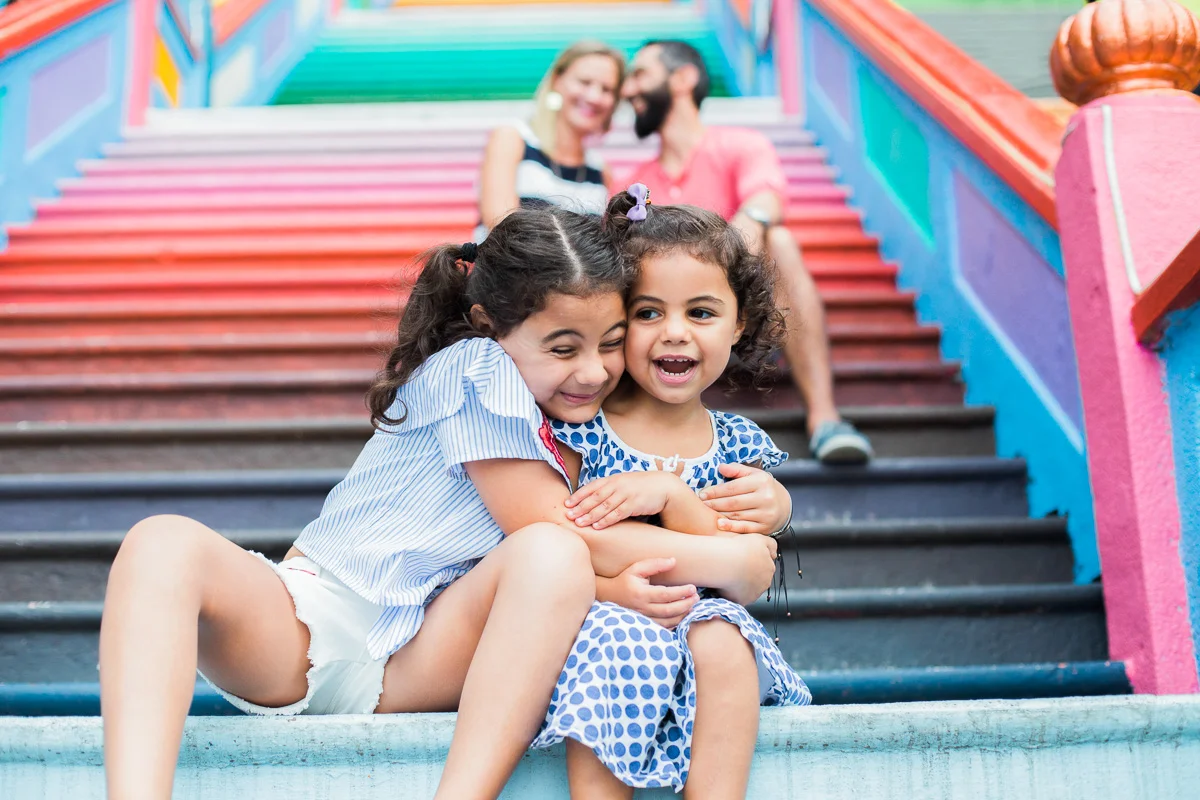 Two little girls give each other a big hug on the steps of Batu Caves in Kuala Lumpur