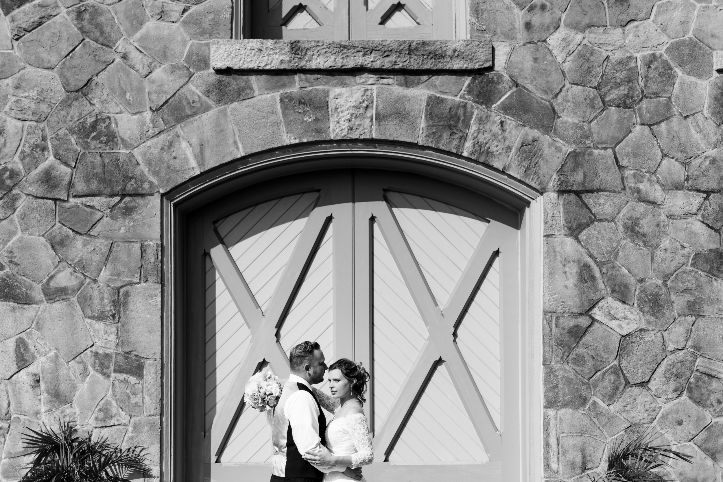 bride and groom on rock wall