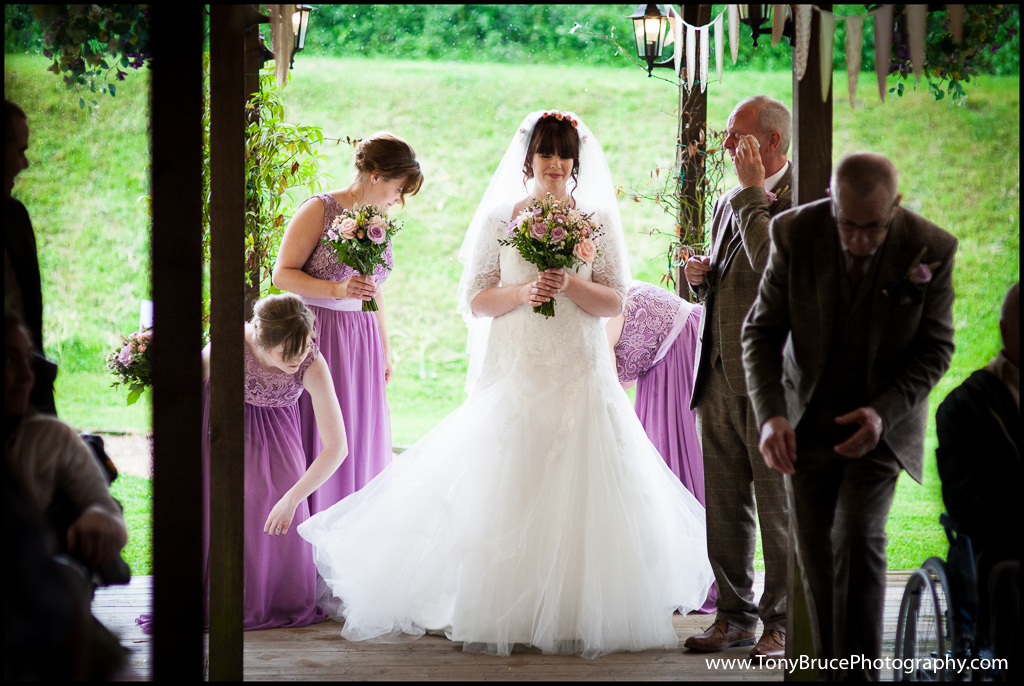 Safe at last. Bride's maids straighten Laura's dress whilst dad mops the rain from his face.