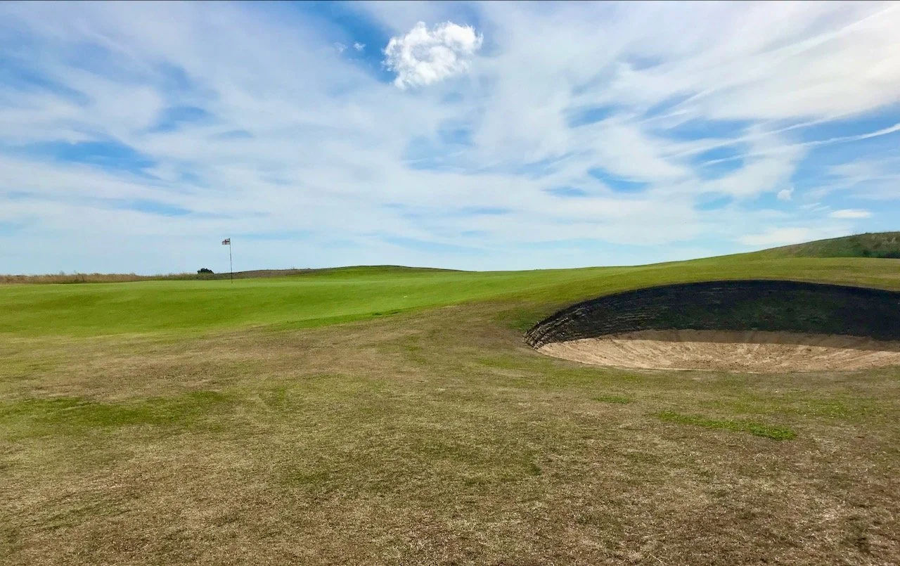 the path passes by a bunker, the green and crosses the fairway