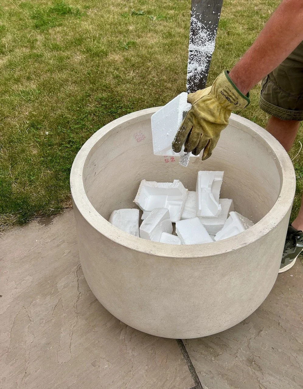 MOH sawing blocks of polystyrene into the large pot for drainage