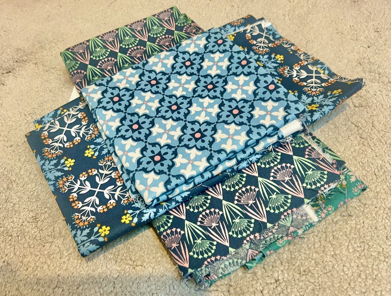 Laying two navy and one lighter blue fabric out to visualise how the final block might work