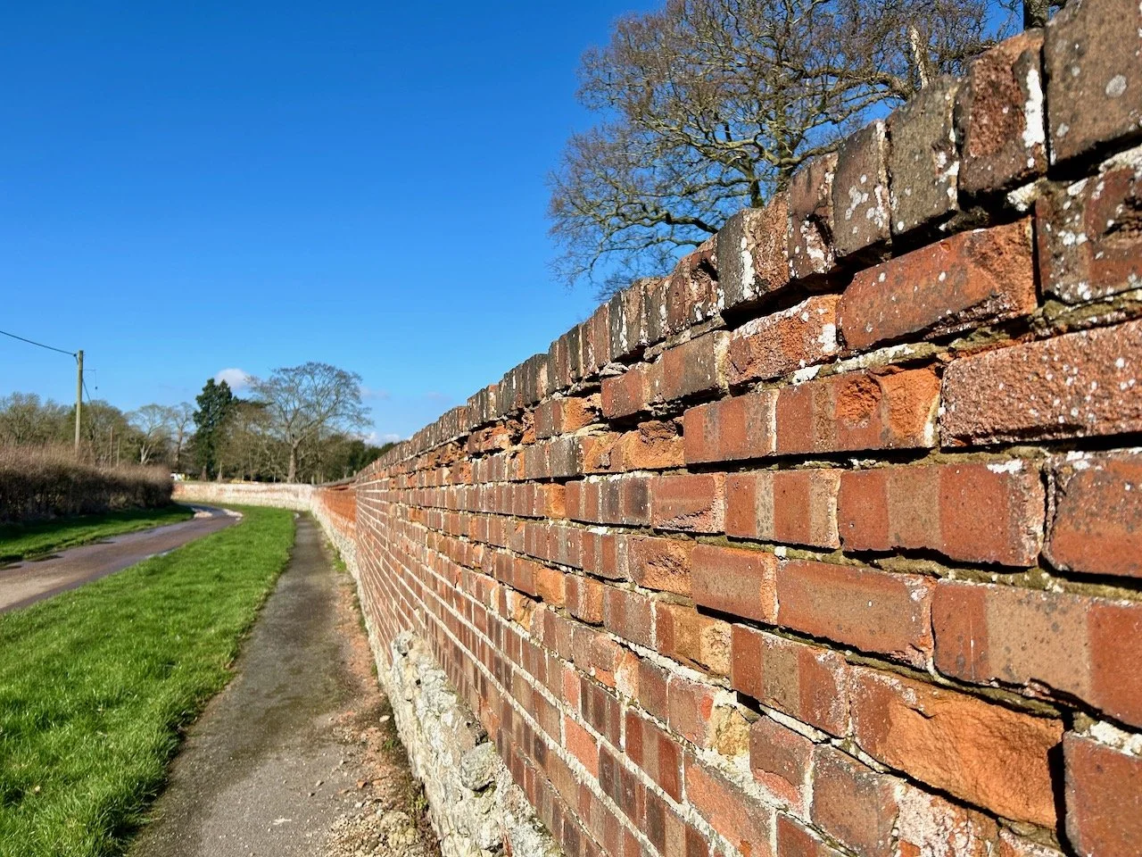 the curved brick wall on Church Lane bordering Stoke Hall