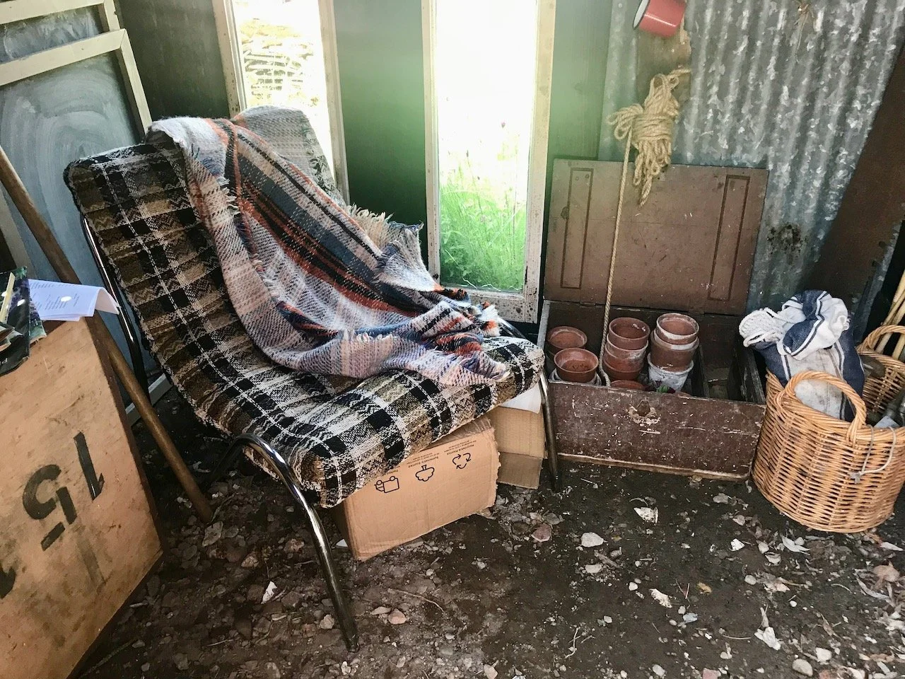 An easy chair, blanket and typical shed paraphernalia in the make do shed