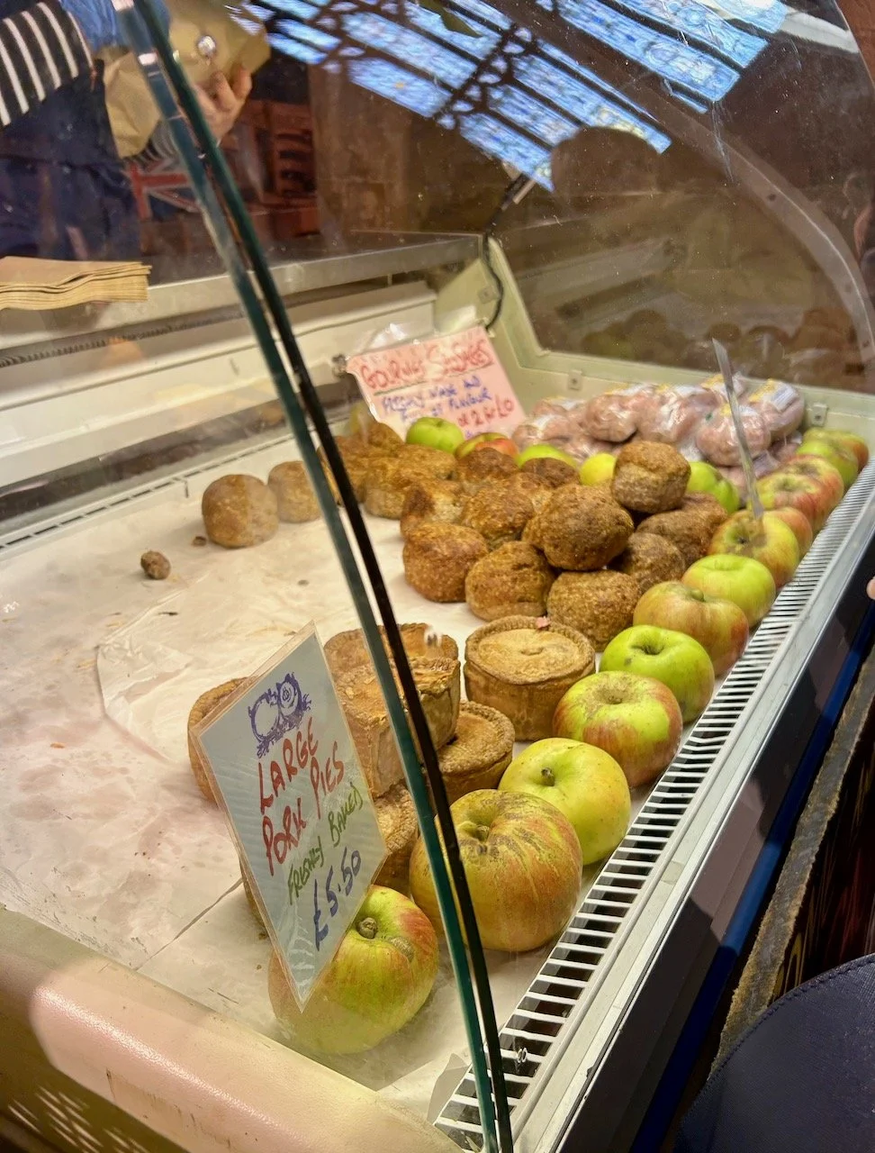 A refrigerated cabinet holding pork pies, haslet and bramley apples in the  main body of the church