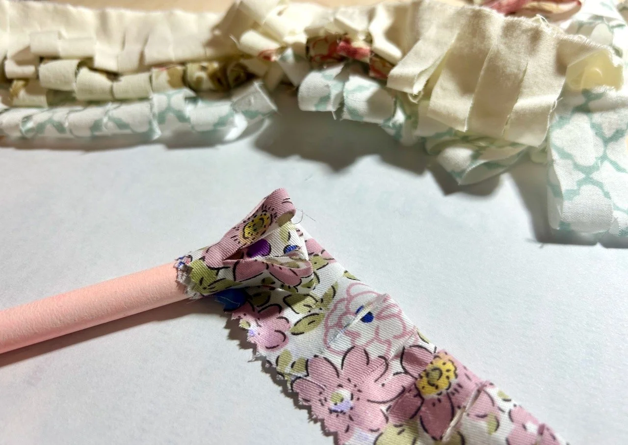 Rolling one of the strips around the pencil