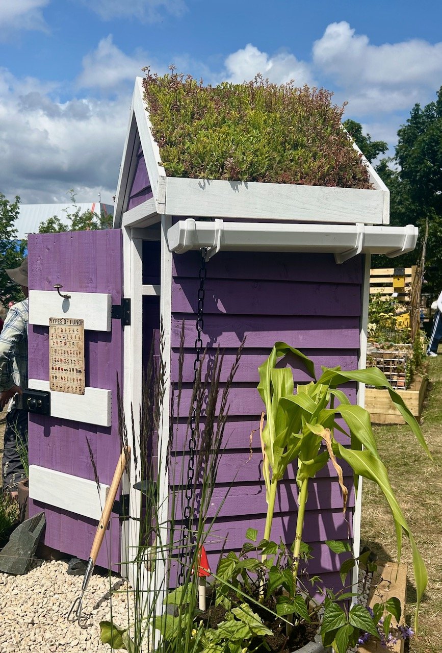 A side on view of the shed with the green roof and white guttering