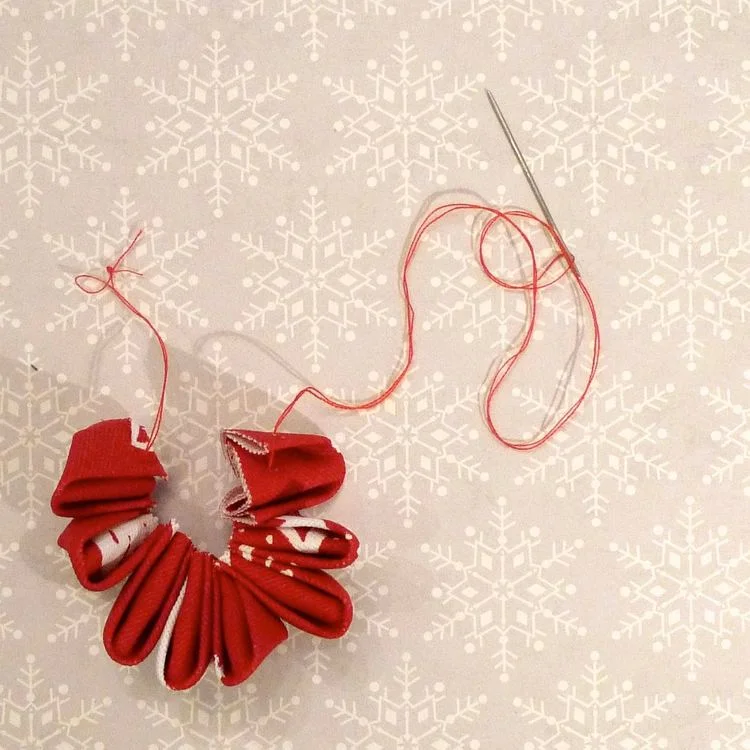 Threading the material petals onto cotton to make the flowers