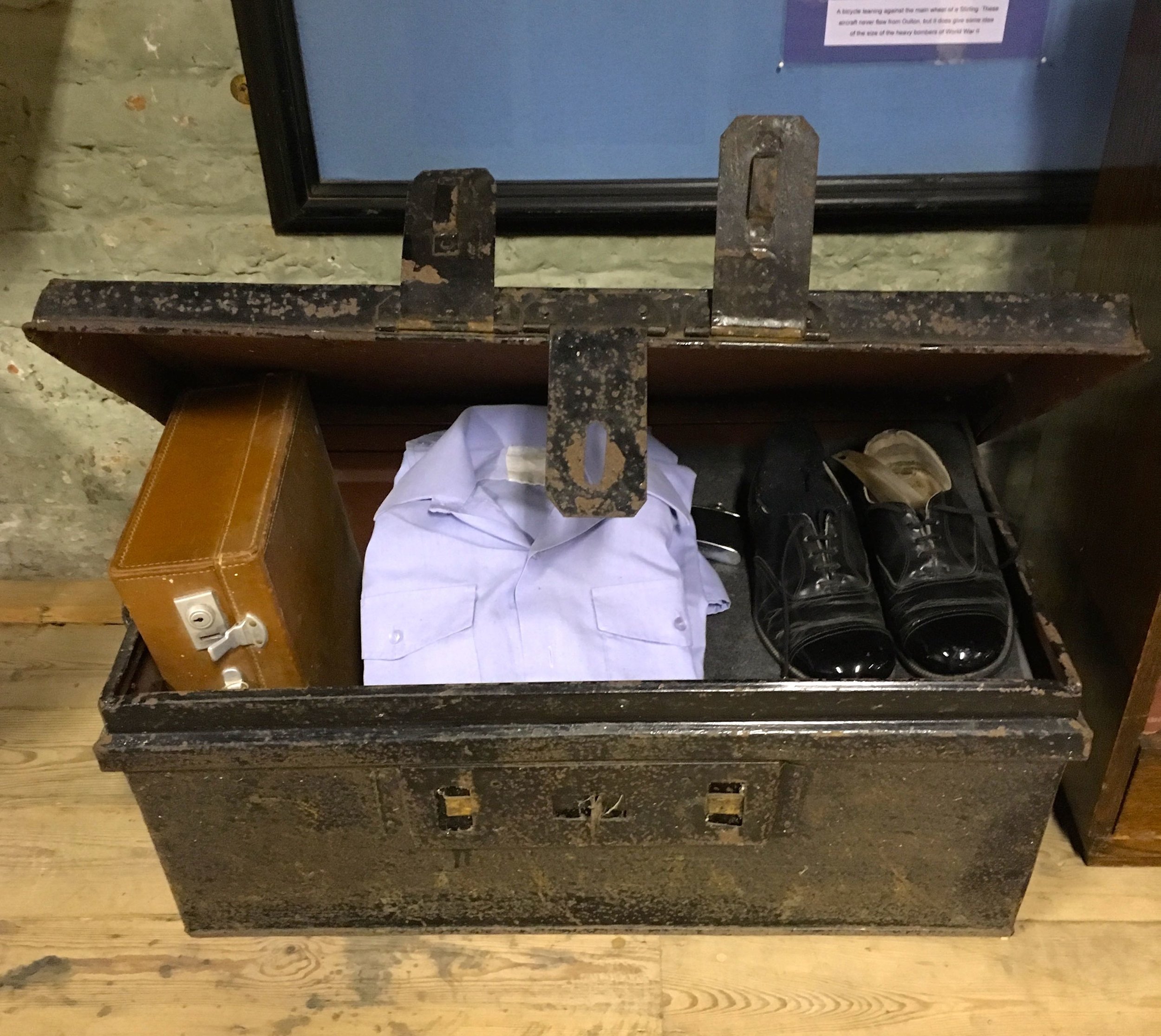 A serviceman's trunk with a serviceman's uniform and kit