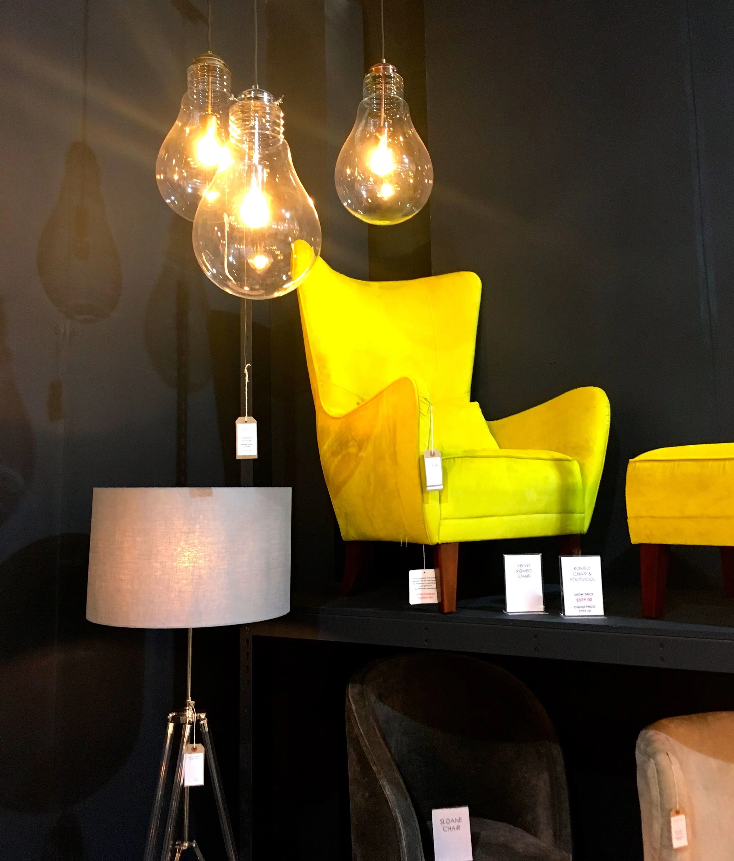 bare lightbulbs and shadows and an armchair on a plinth