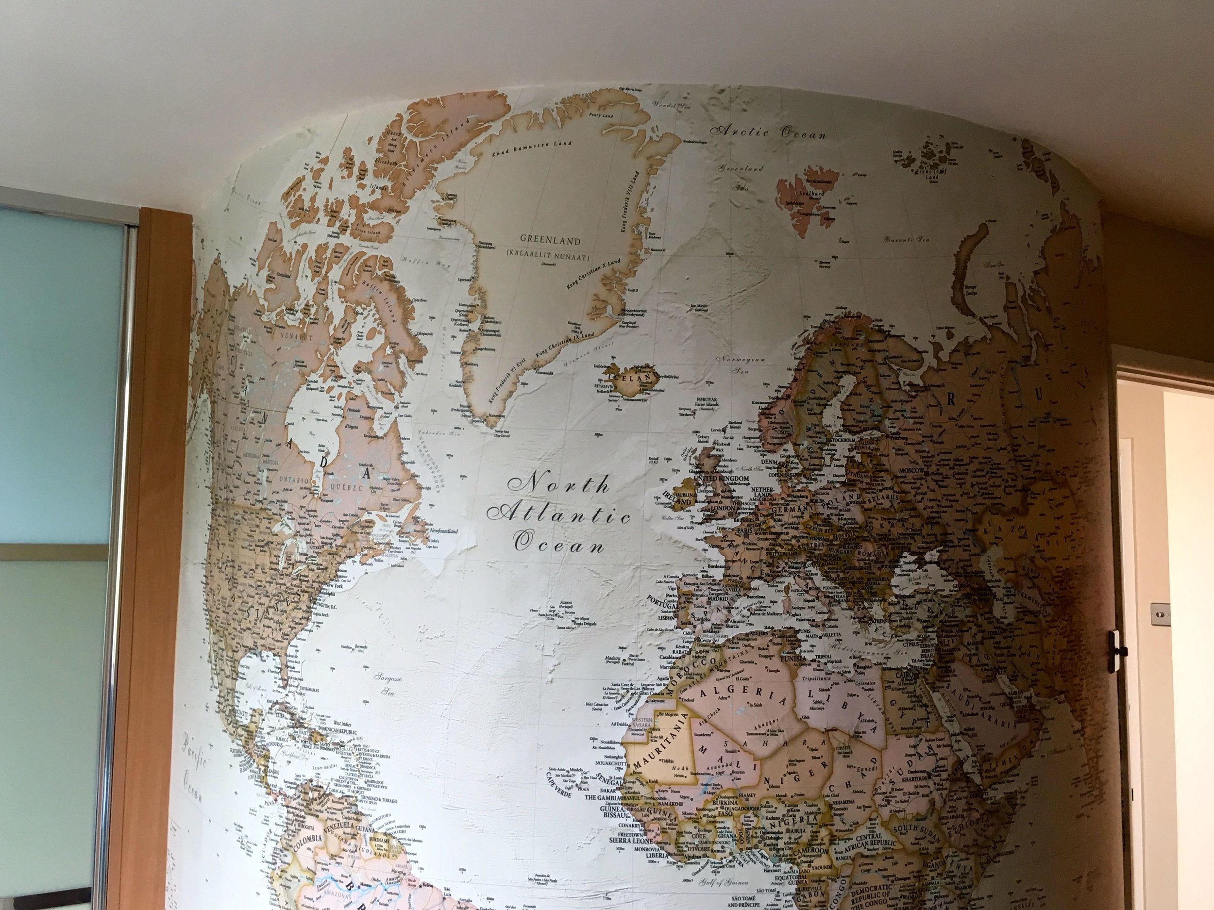 A map on a round wall has a globe life effect