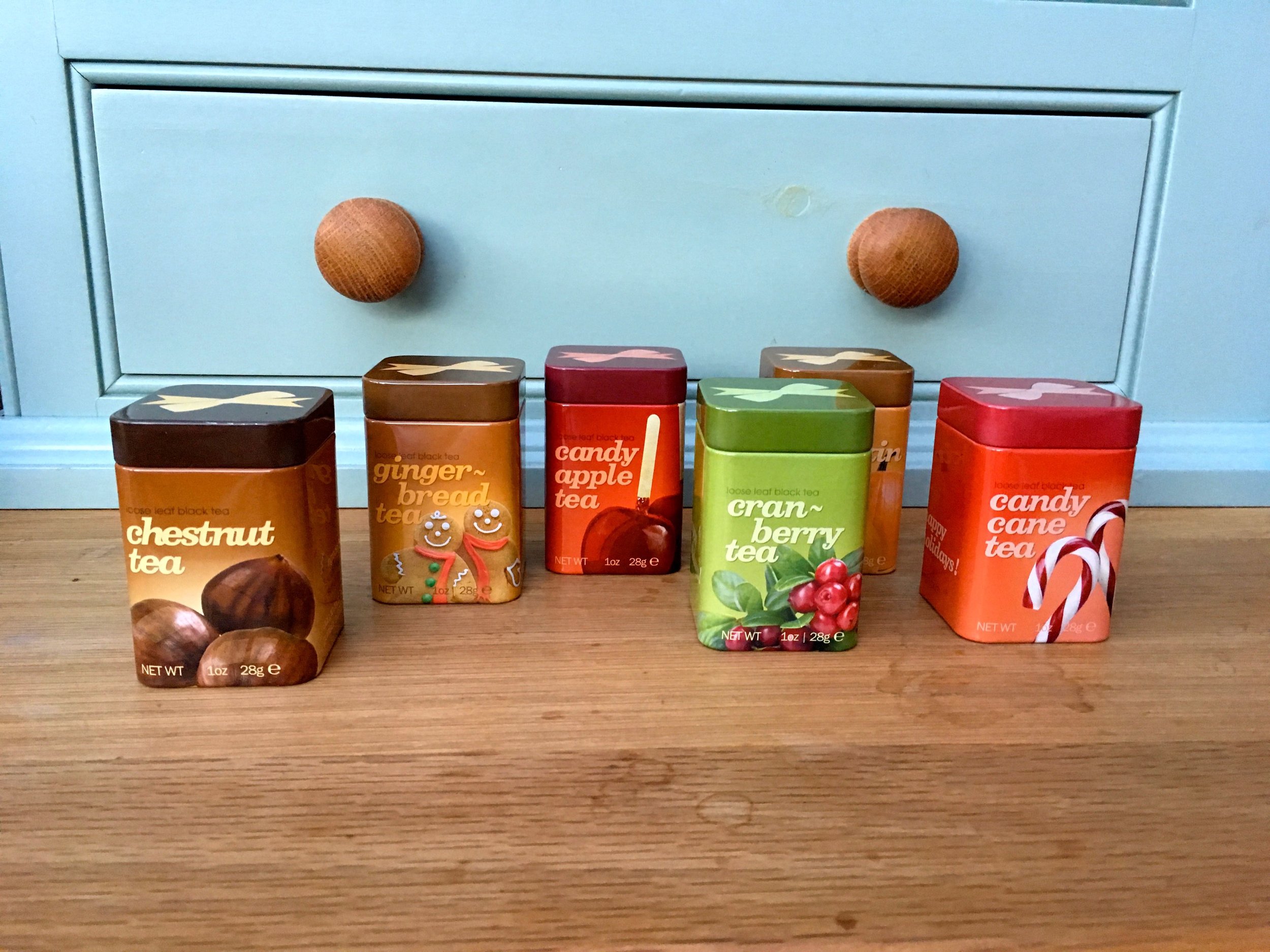 CHESTNUT, GINGERBREAD, CANDY APPLE, CRANBERRY, PUMPKIN AND CANDY CANE TEAS IN MINIATURE TINS, FULL OF HOLIDAY CHEER