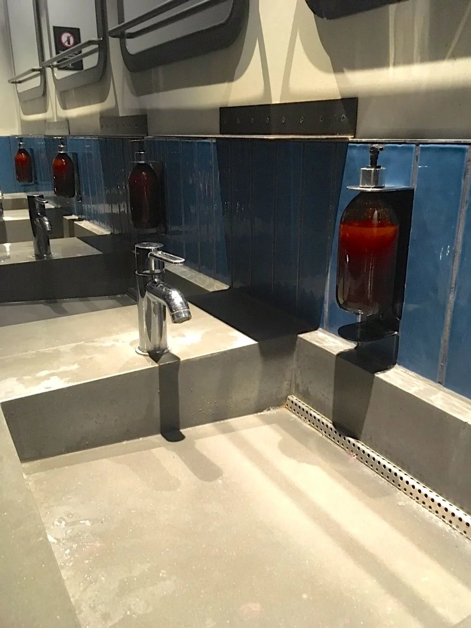 concrete sinks and blue tiles