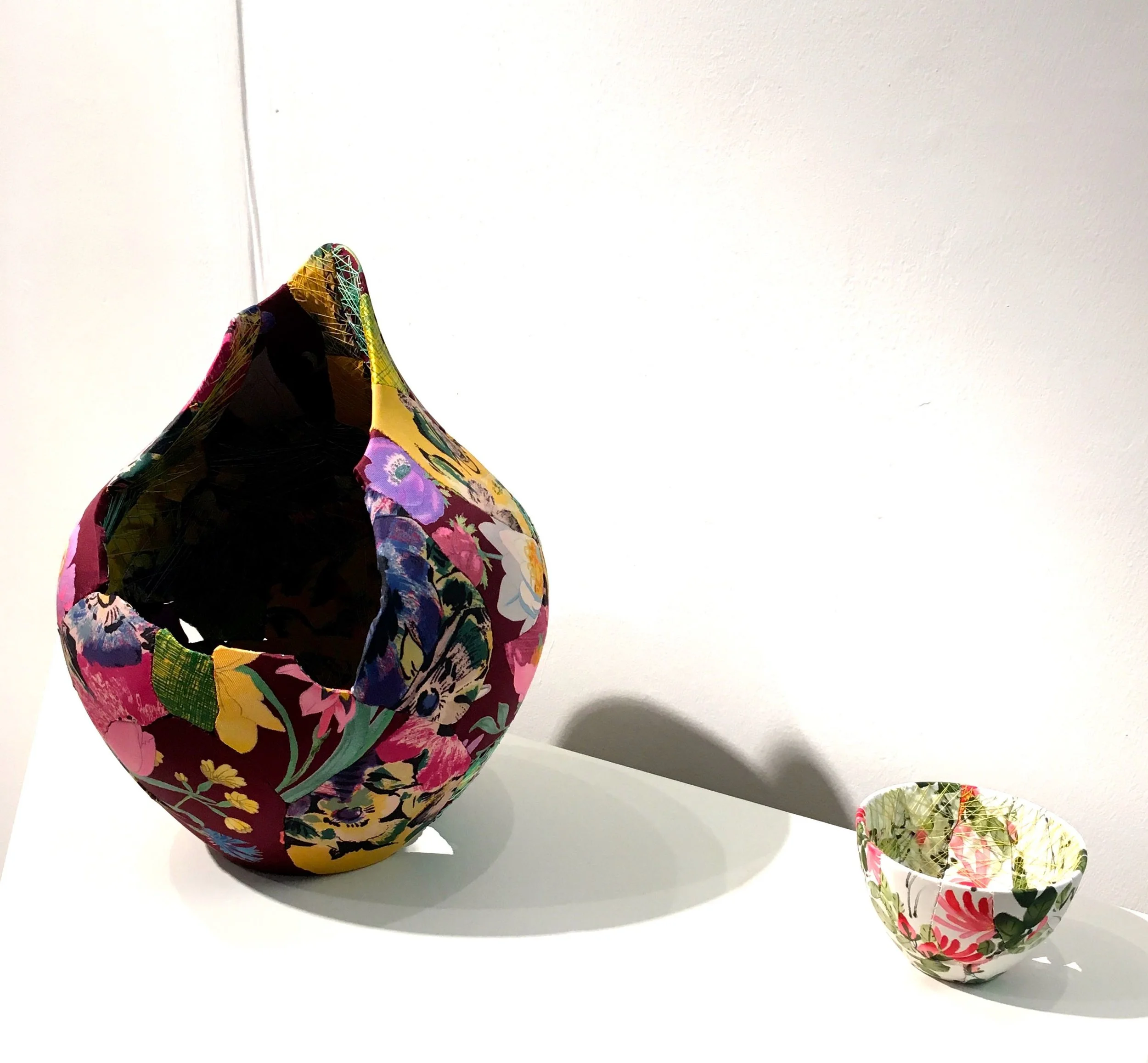 fragments of pottery covered in silk and sewn together to create pieces of art