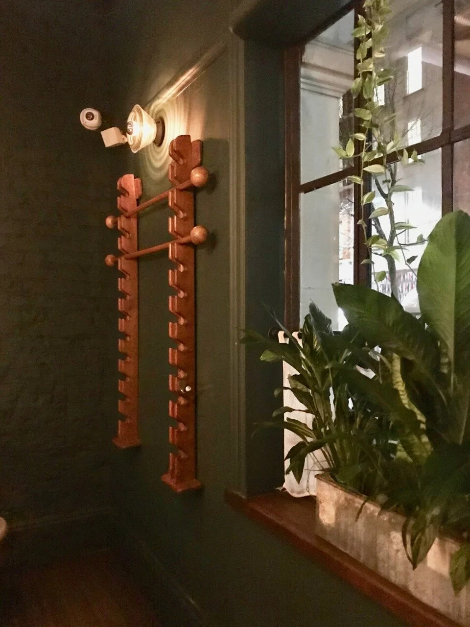 sage green walls and a rack for newspapers