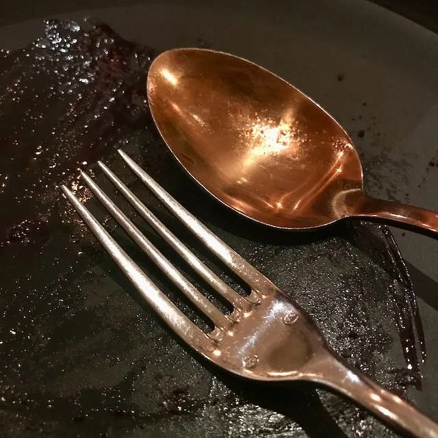 an empty plate with fork and spoon