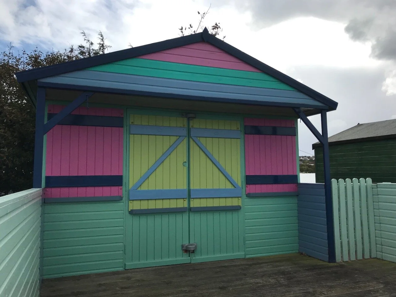 pink turquoise and green boldly coloured beach hut