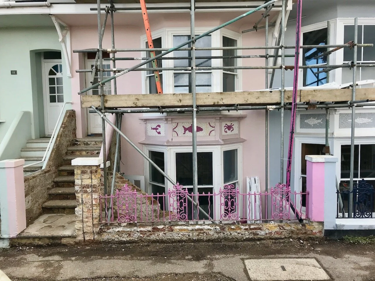 pink bay fronted house with scaffolding