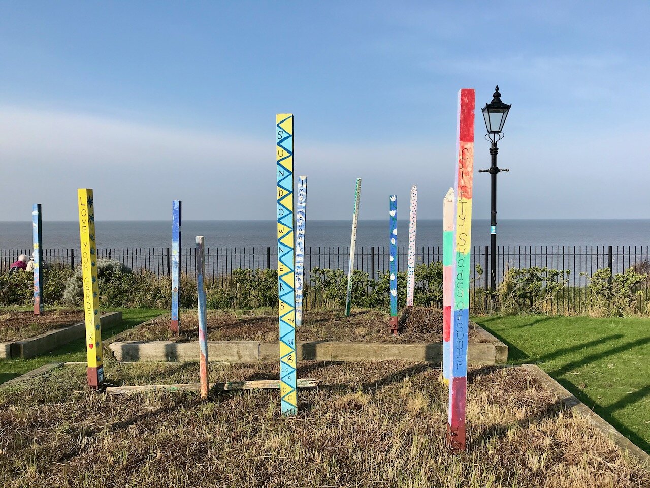 painted fenceposts looking out to sea