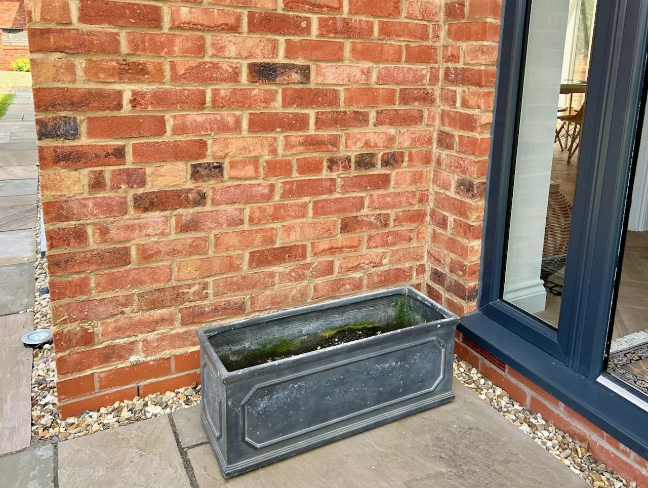 A grey oblong planter (from our old garden) outside our back door