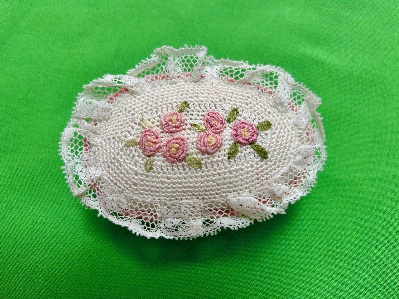The top of the crocheted pin cushion complete with rose embroidery