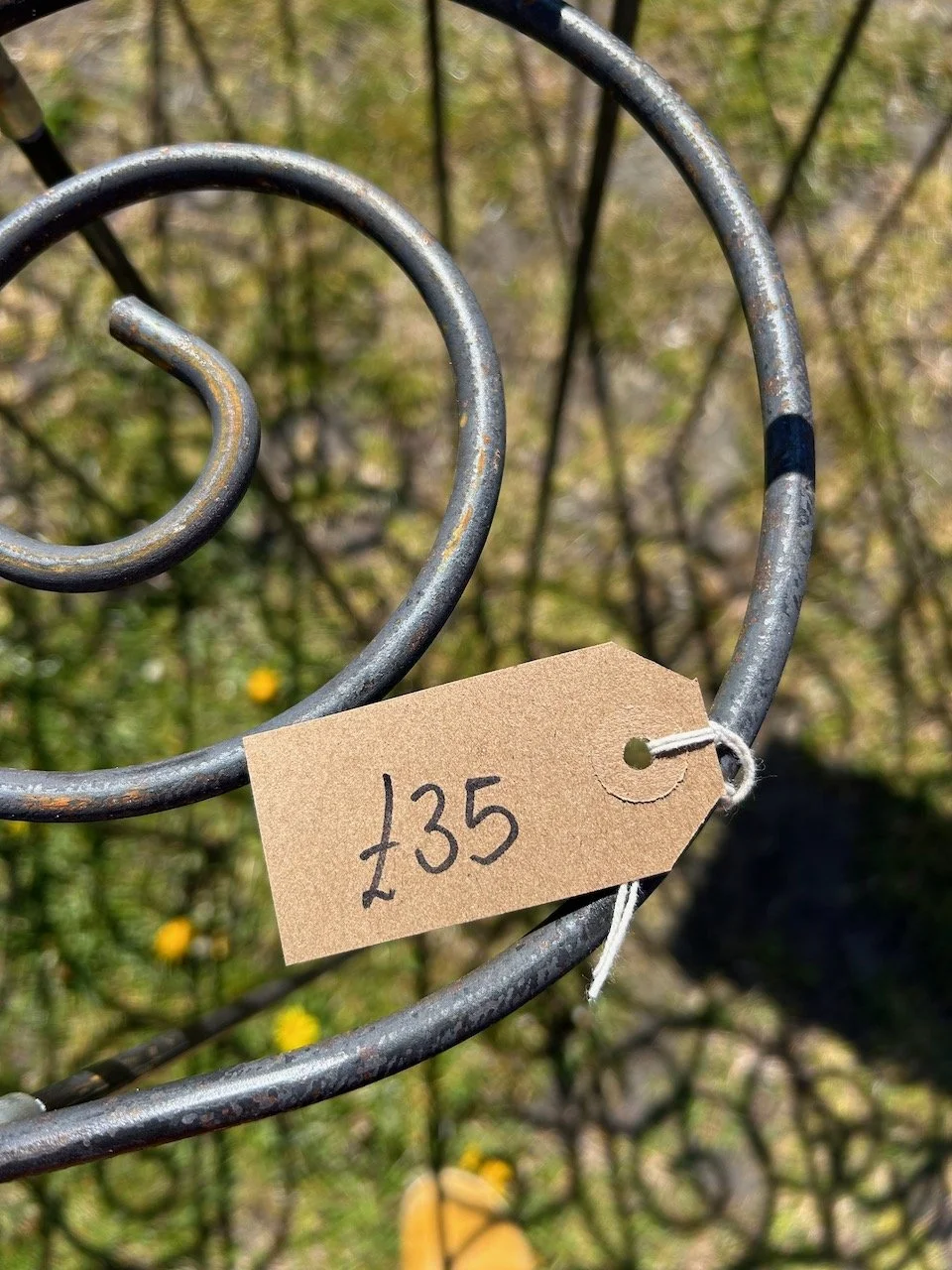 A card price tag on a steel circular plant support