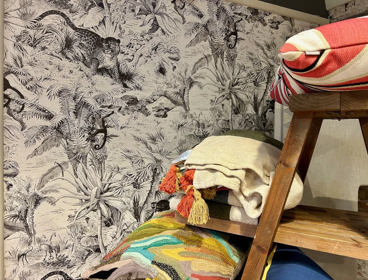 A black and white jungle style print with monkeys and large cats, and flamingos