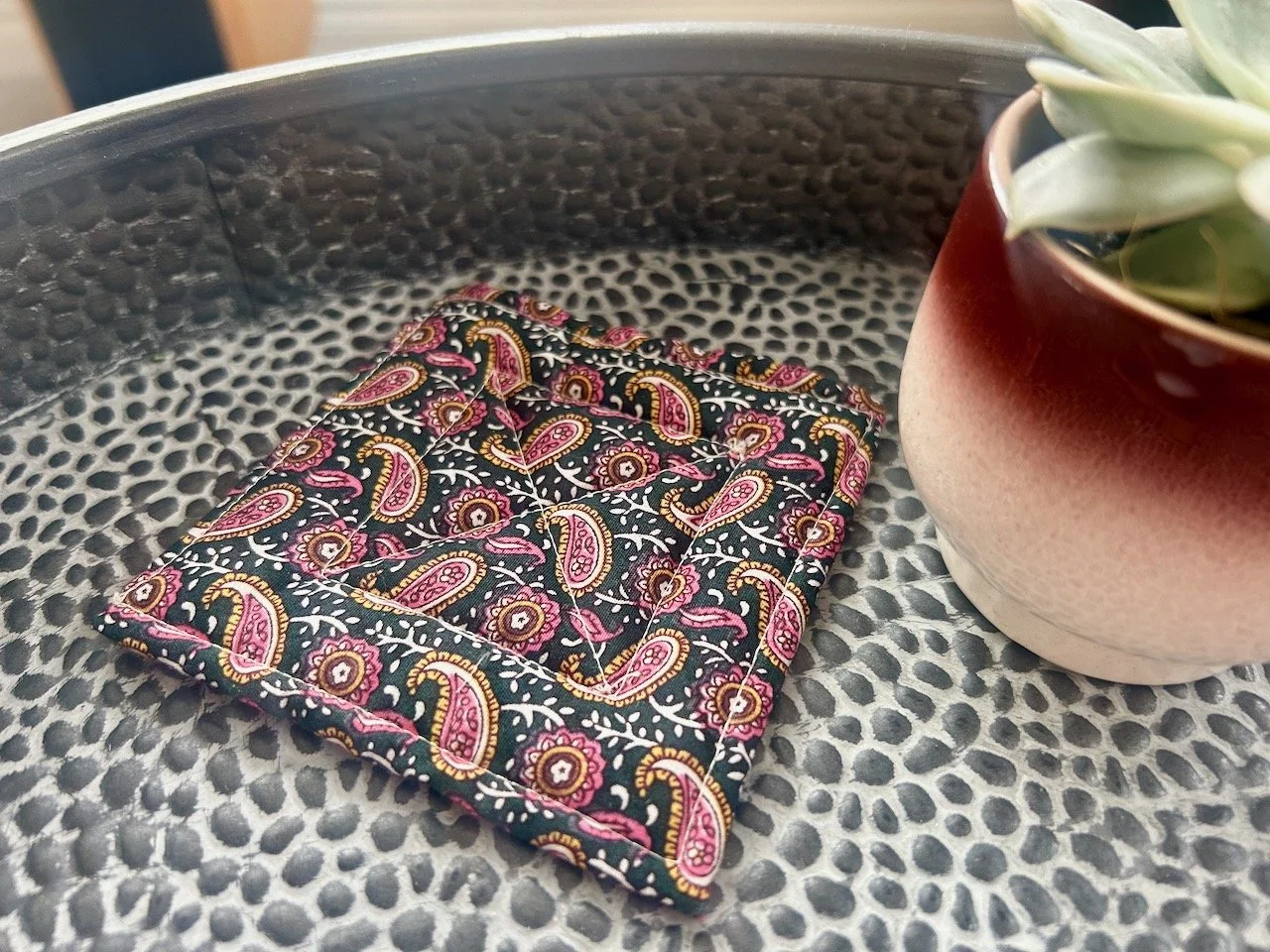 The simple paisley quilted mat on the textured metal table