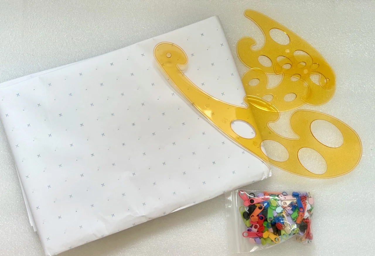 dot and cross paper for patterns, amber curved rulers and a bag of zipper pulls