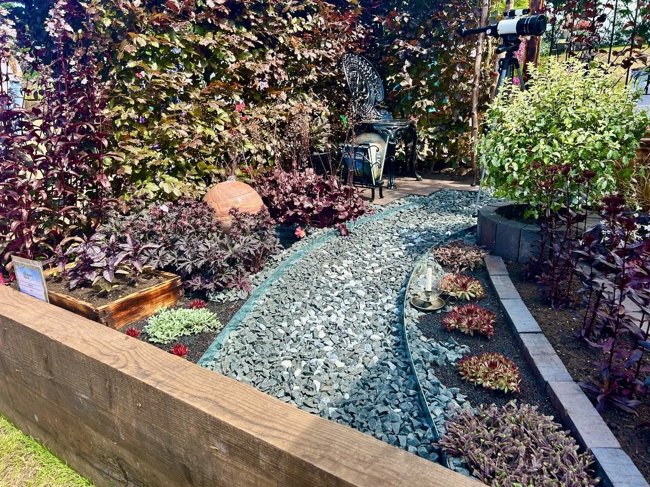 Dark leafed plants either side of the gravel path which repesents the Milky Way