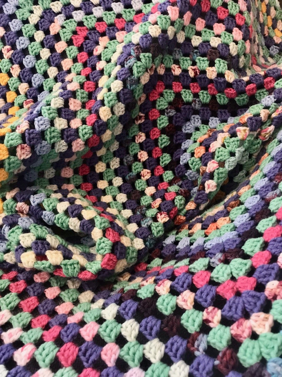 A close up of a large granny square blanket