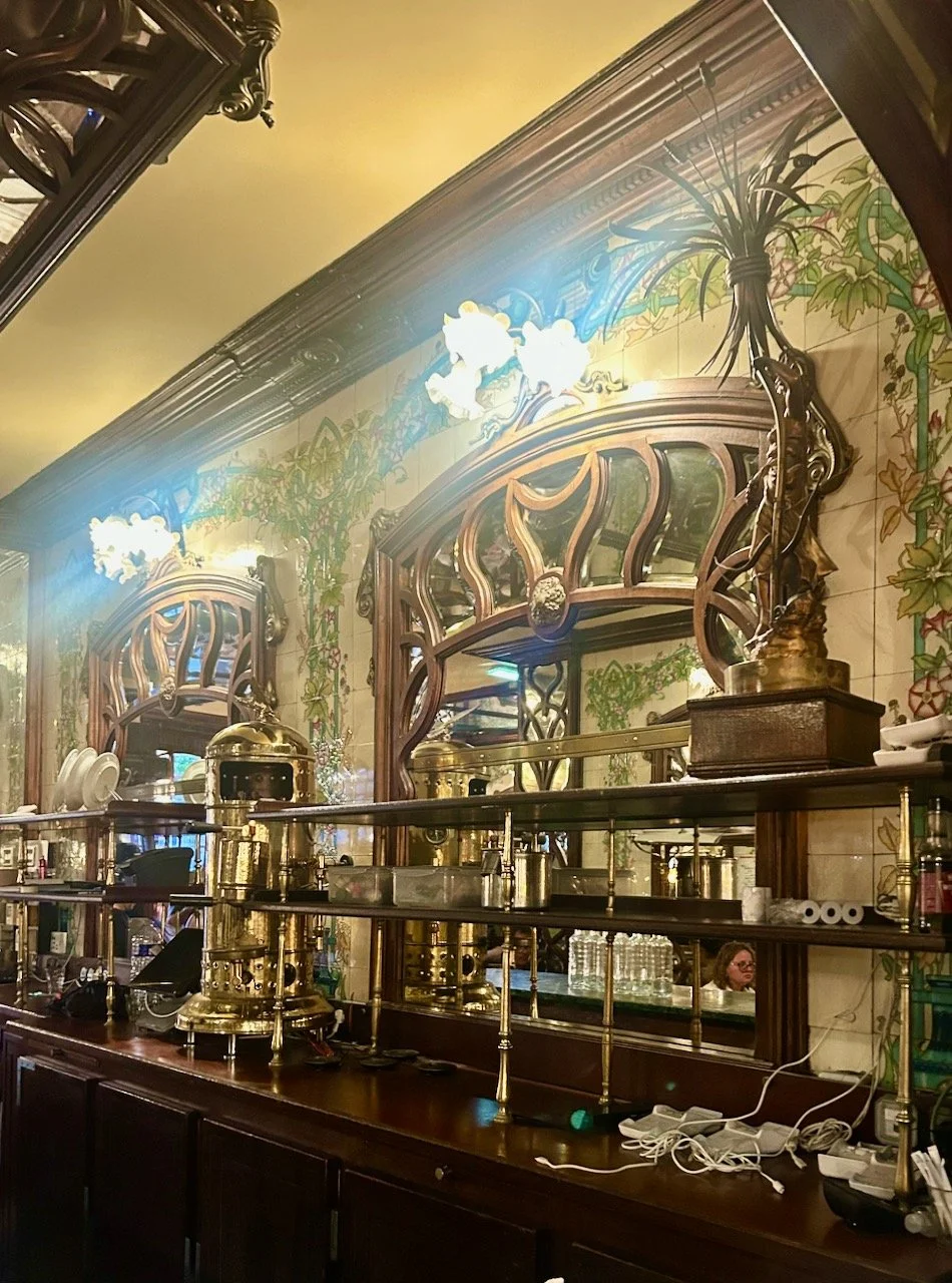 The carved mirrors and ornate wooden furniture in the serving area/bar