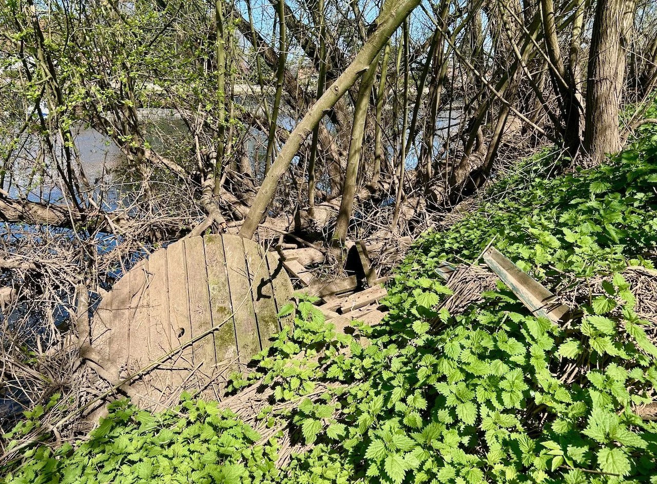 An old wooden table and plastic chairs discarded by the jetty