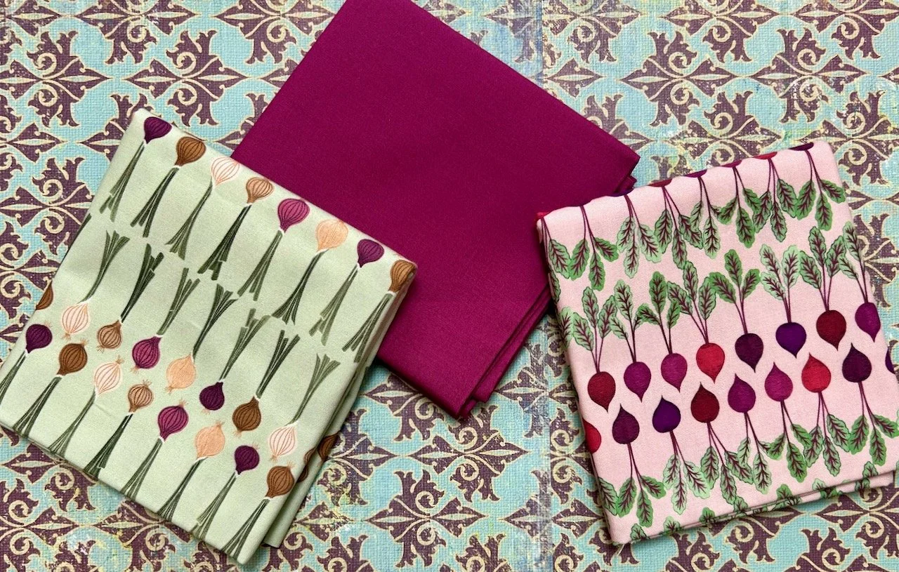 fabric with onions and another with beetroots, in between is a complementing plain fat quarter