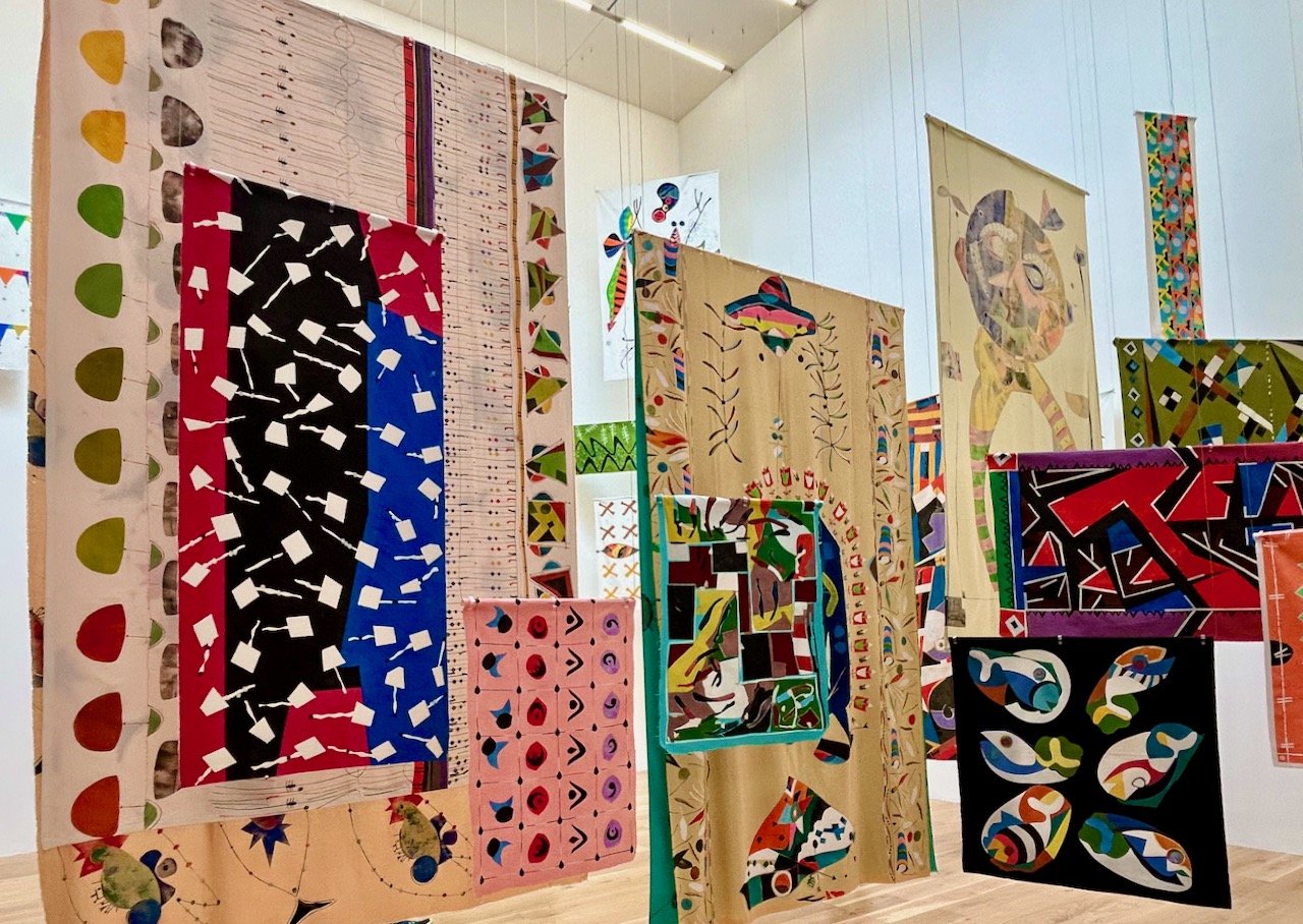 various textiles hung around the gallery space