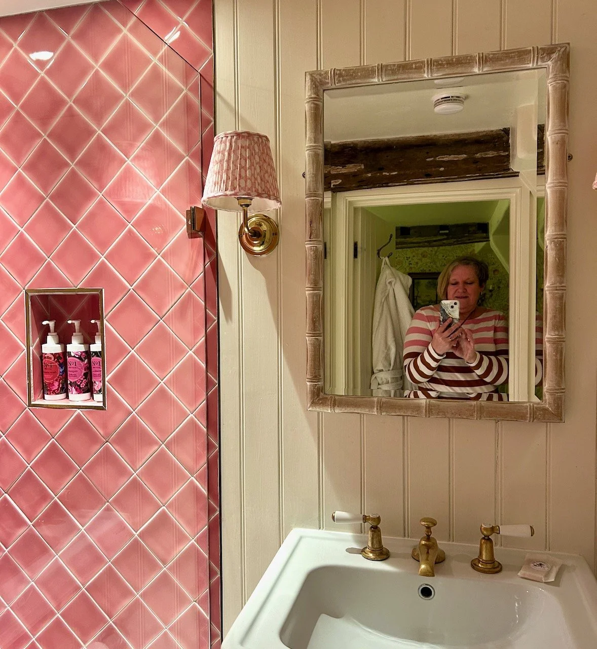 Me in the mirror somehow managing to dress to match the pink tiled shower enclosure