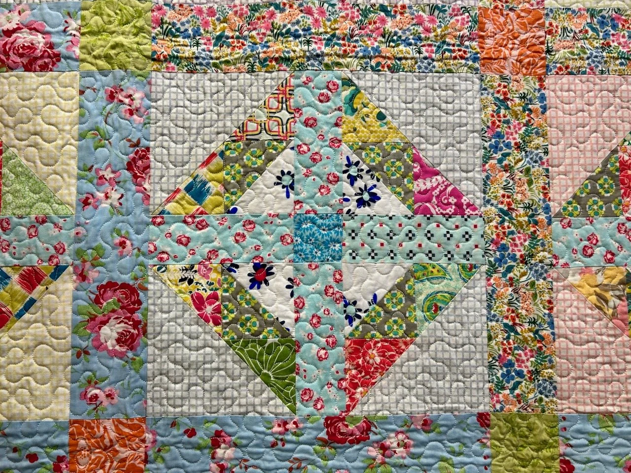 PART OF THE SCRAPPY CROSSES QUILT USING MULTIPLE FLORAL FABRICS