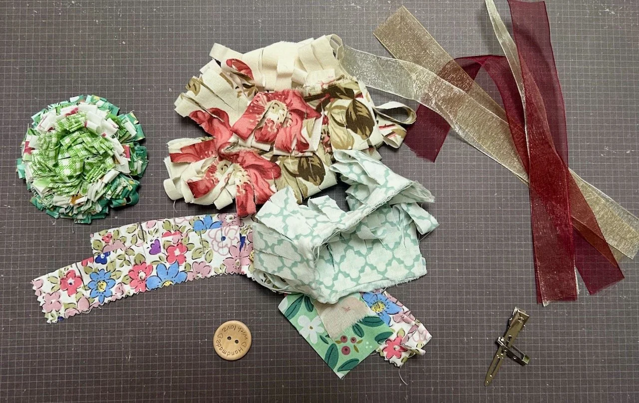 A shabby chic rosette, strips of fabrics and ribbons plus a wooden button and a brooch/hair clip attachments