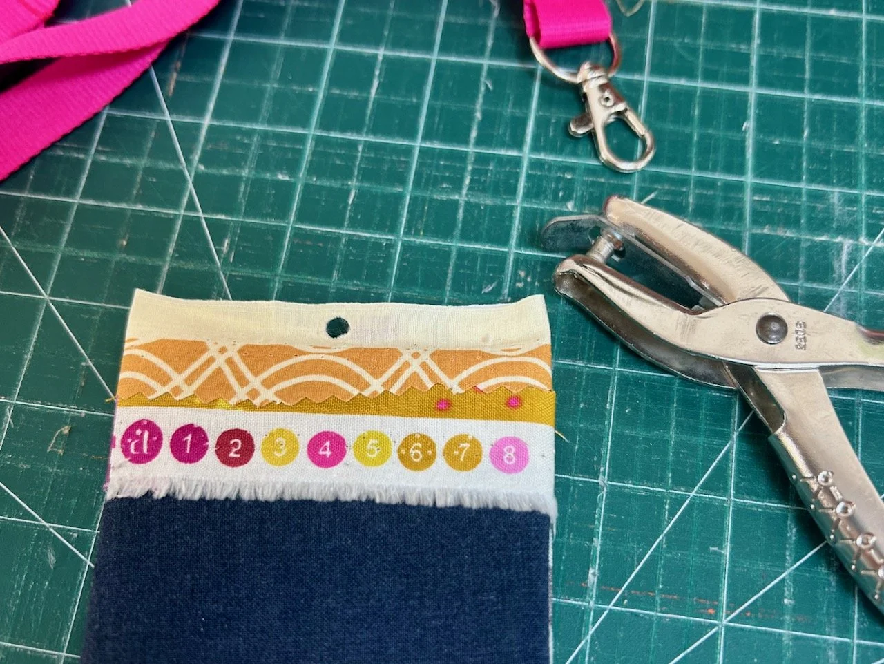 Using my vintage ticket clipper to make a single hole in the fabric I'd stuck onto the clothes tag