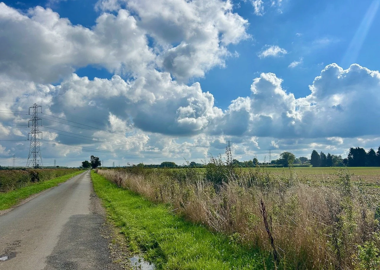 Looking down Moor Lane with the fluffy clouds and blue sky above