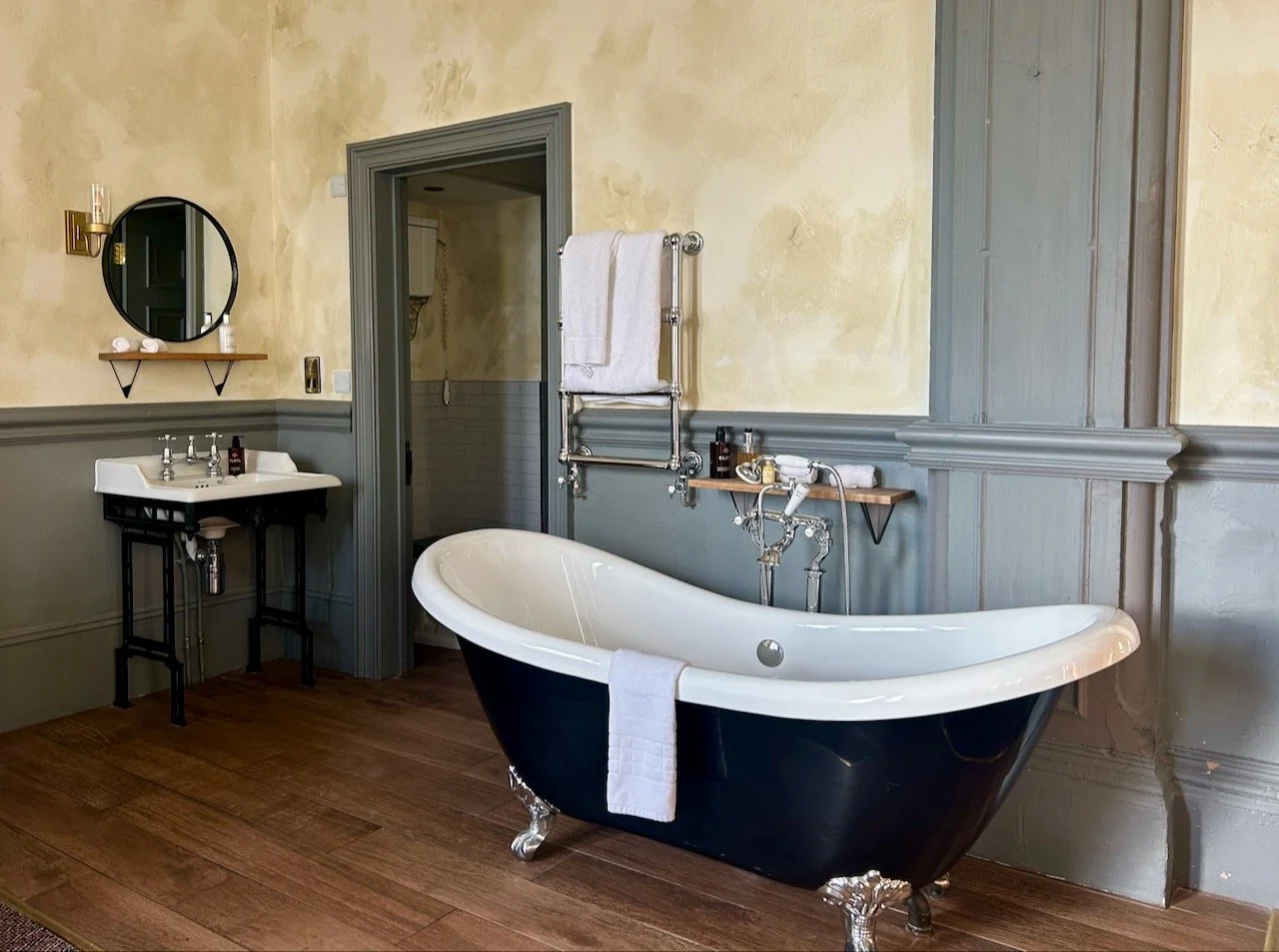 A corner of the fancier than expected room with a roll top bath and basin.  The TV was above the fireplace (not shown) to the left of the basin