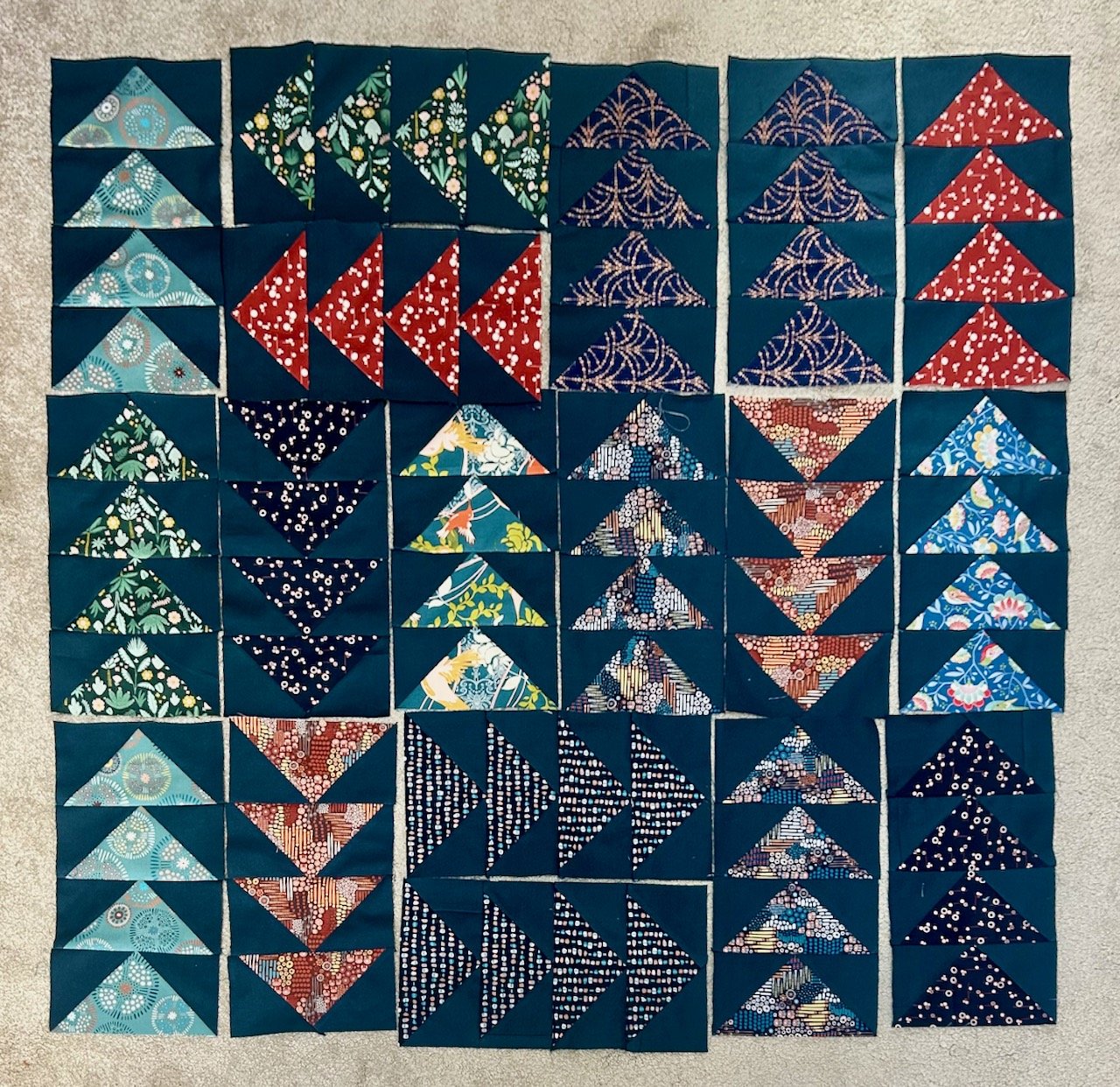 A jumbled layout of flying geese blocks - about a quarter of what I need to make