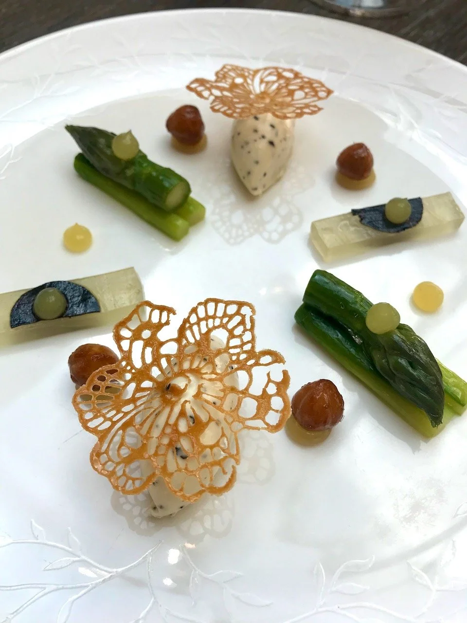my asparagus starter, all delicately placed on a white plate with truffle, hazlenuts and delicate flower shaped tuille