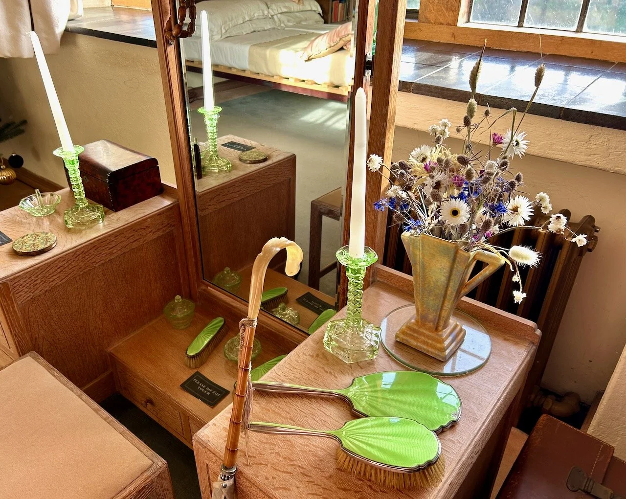 Another green vanity set on the dressing table with green glass candlesticks and other accessories