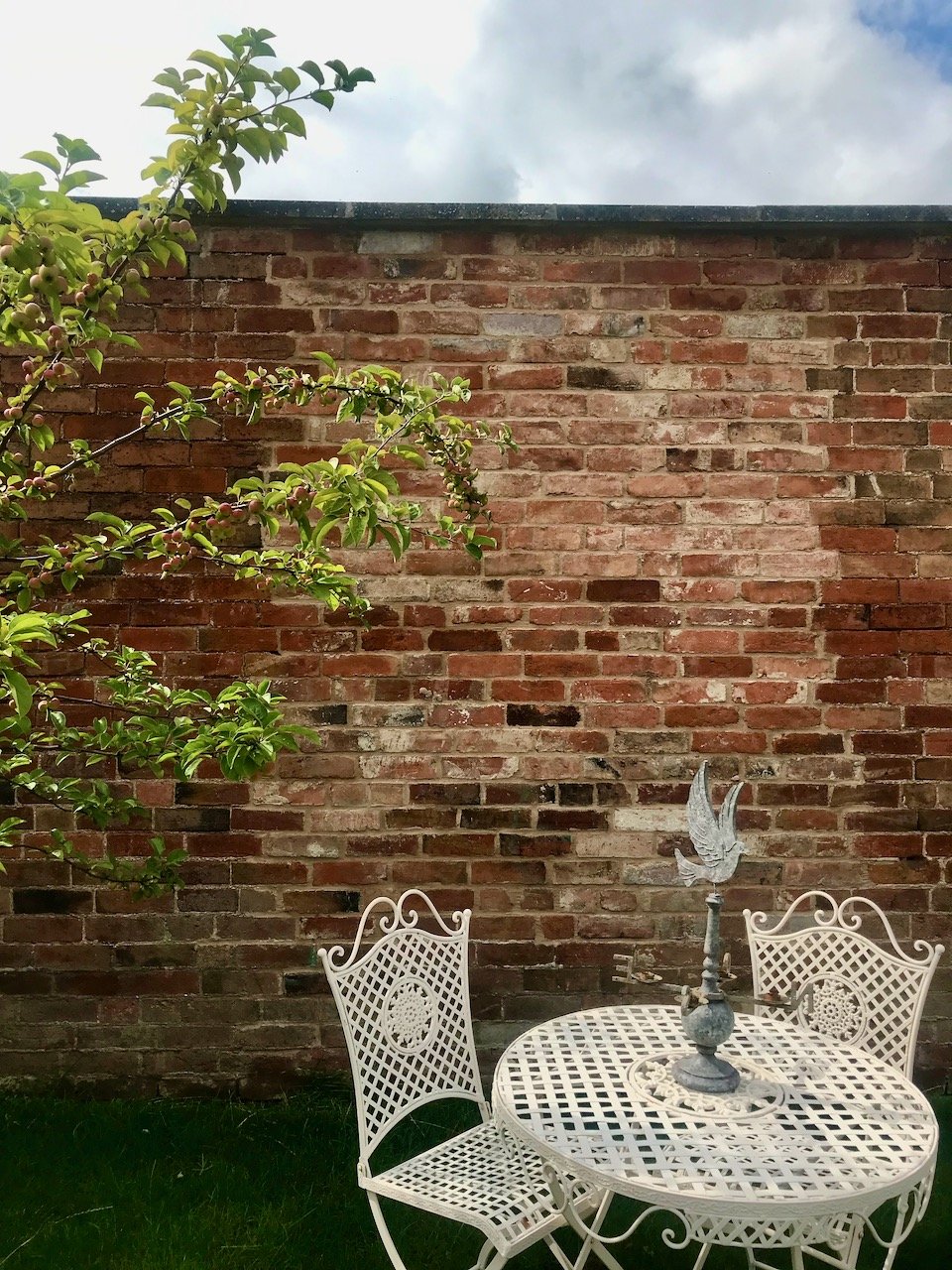 our cream lattice table and chairs in front of the wall