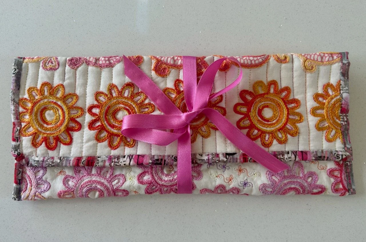 A pink and orange embroidered pouch