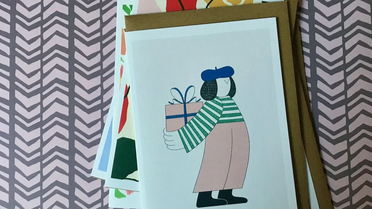 A hand drawn female wearing a beret, striped top and trousers holding a present behind her back